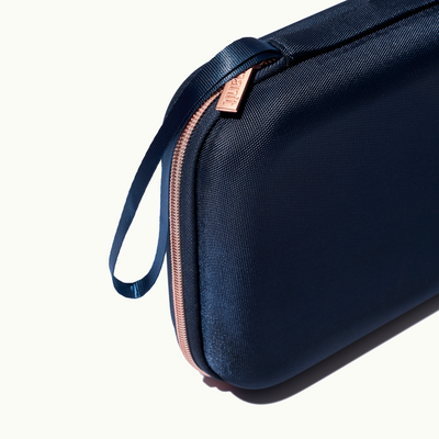 zoomed in picture of rose pink zipper and strap on blue travel case