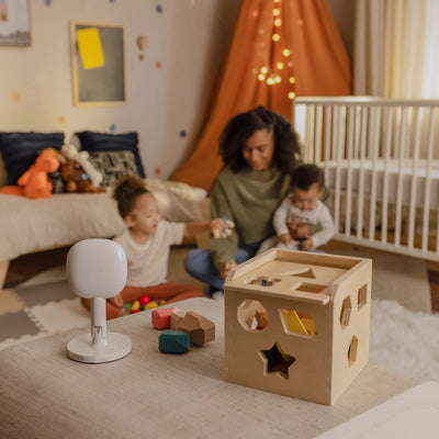 Mom playing with kids with nanit pro with flex stand in foreground