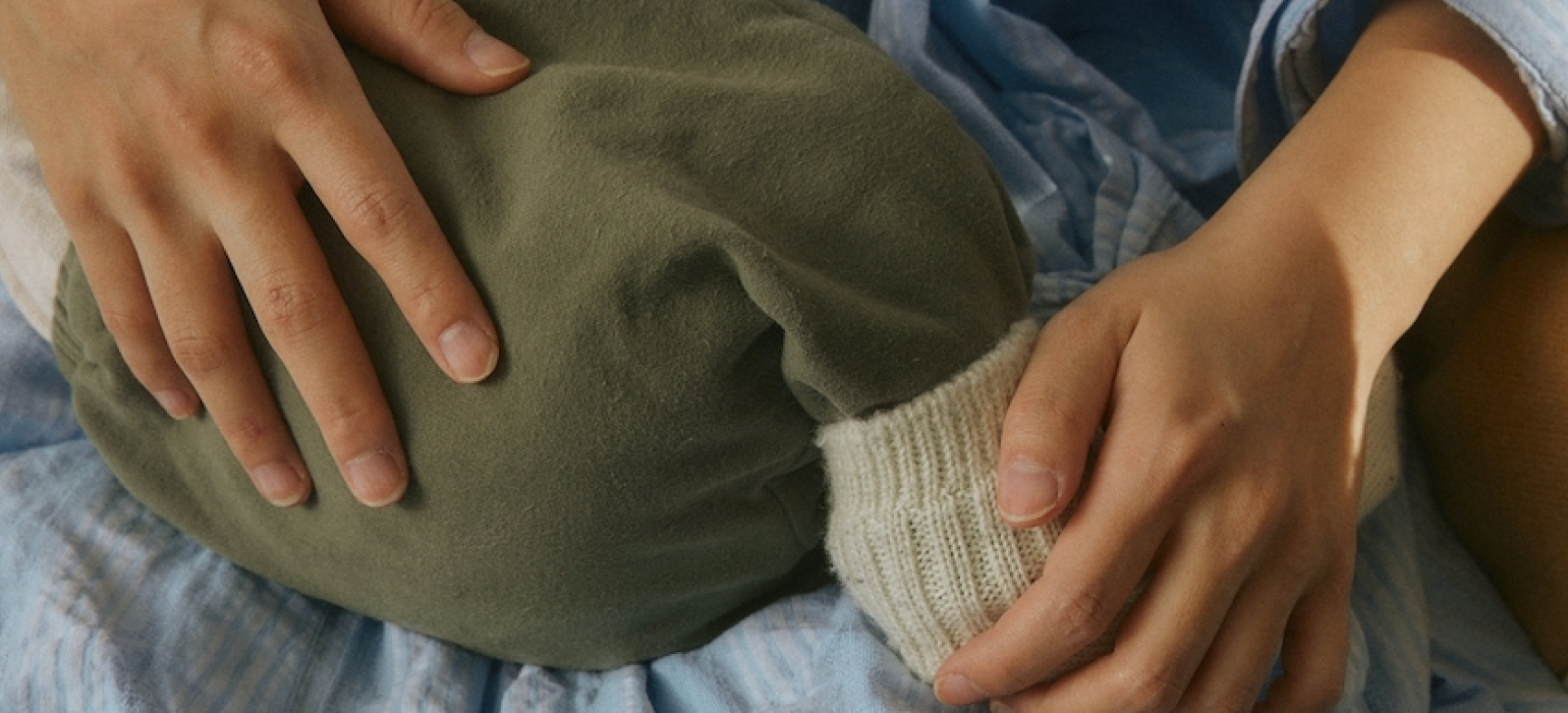 Close up of mom and baby being help with a pair of green pants