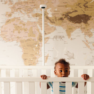 Image of baby in crib with nanit pro camera + floor stand behind 